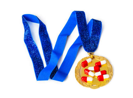 Gold medal and pills isolated on white backgroundの写真素材