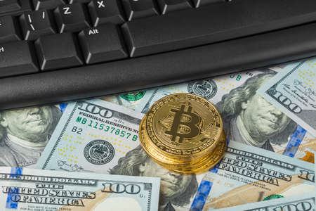 Computer and bitcoins on money - business technology background