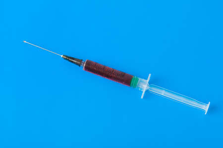 Medical syringe on blue background