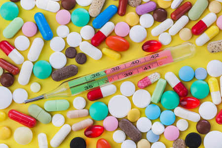 Pills and thermometer - abstract medical background
