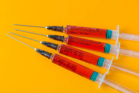 Medical syringes on orange backgroundの写真素材