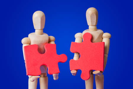 Wooden toy figures with puzzle on blue backgroundの写真素材