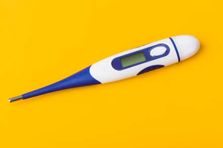 Electronic medical thermometer with blank screen isolated on yellow backgroundの写真素材