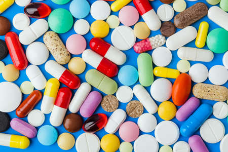 Heap of pills - blue medical background