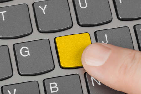Computer notebook keyboard with blank yellow key - technology background