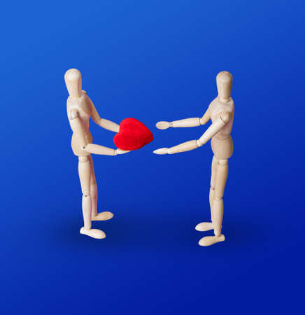 Wooden toy figures with heart on blue background