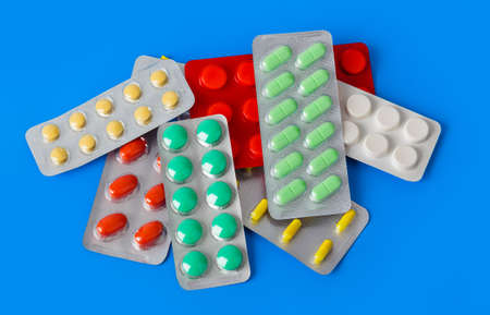 Packs of pills isolated on blue background