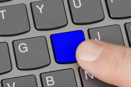 Computer notebook keyboard with blank blue key - technology backgroundの写真素材