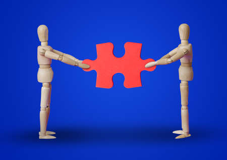 Wooden toy figures with puzzle on blue backgroundの写真素材
