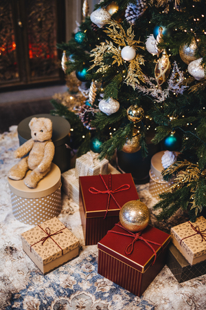 Vertical picture of decorated Christmas tree with balls and many presents under fir tree. Pleasant moments and festive event. Composition of pile with gifts. New Year`s holidays.の写真素材