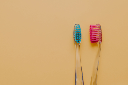Horizontal shot of plastic toothbrushes used for cleaning teeth, care of oral cavity, isolated over yellow background, empty space for your textの写真素材