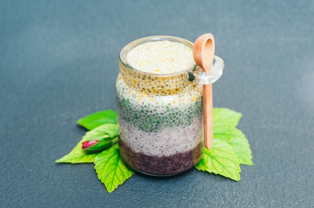 Healthy dessert and proper nutrition concept. Chia pudding in glass jar with wooden spoon. Chia seeds. Superfood. Selective focus. Milk dessertの写真素材