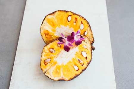 Fresh ripe jackfruit. Tropical fruit with purple orchids on it. Jackfruit segment ready to eat. Organic food. White background. Healthy eating conceptの写真素材