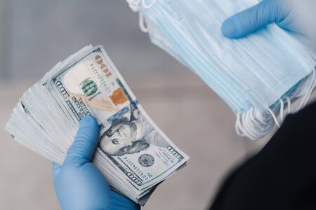 Unrecognizable man earned much money after selling medical masks, wears protective gloves....