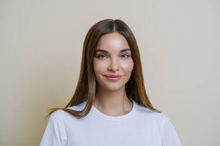 Tender feminine woman looks with admiration and affection, wears white t shirt, has makeup, healthy...