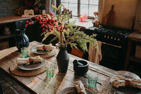 Served nicely decorated dining table with plates napkins vase. Kitchen background interior. Catering concept. Retro style. Interior designの写真素材