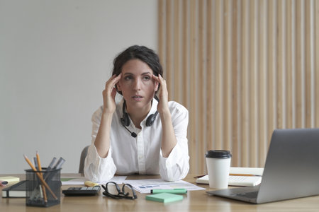 Frustrated business woman feeling tired while sitting at table in office, thinking about problem...