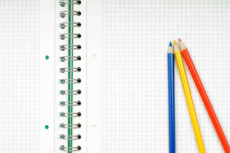 close up of notebook and pencil on white background