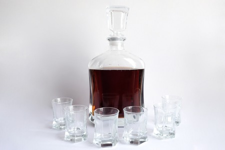 Decanter and six glasses with empty whiskey white backgroundの写真素材