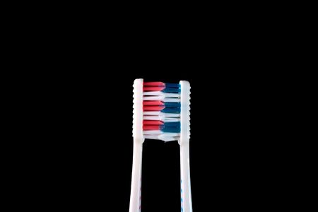 Two new tooth brushes on a black background.の写真素材