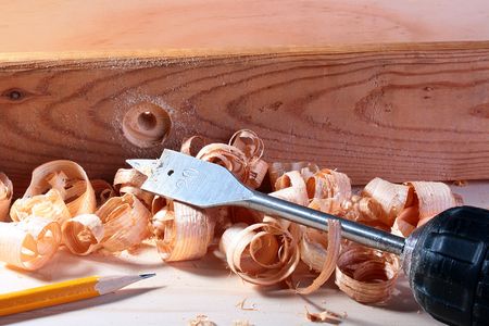 Drill with a thrill for a wood in a workshop. The aperture in a wood is made in the work beginning....