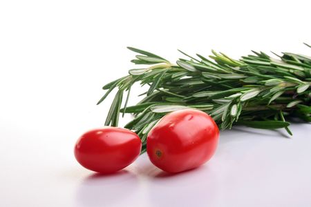 Two small red tomatoes and saffron branch.の写真素材