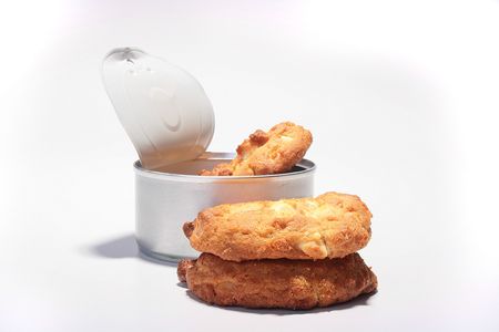 Three sweet cookies from a can on a white background.の写真素材