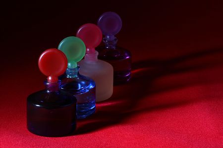 Colour bottles of the small size for cosmetics storage on a red background.の写真素材