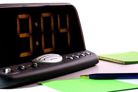 Electronic clock for office or the house, show time. In the foreground the handle and leaves of a...