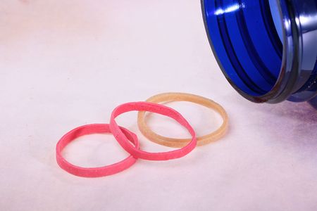 Neck of plastic packing of dark blue colour for medicines and three rubber rings for fastening of...