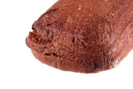 Loaf of black bread of the oblong form on a white background.