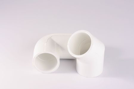 Connectors with a bend for connection of pipes, are made of white plastic.