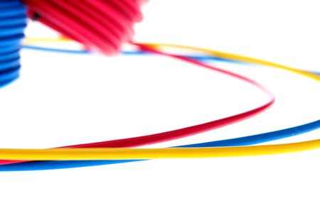 Electric wires of red, yellow and dark blue colour are winded in rings.の写真素材