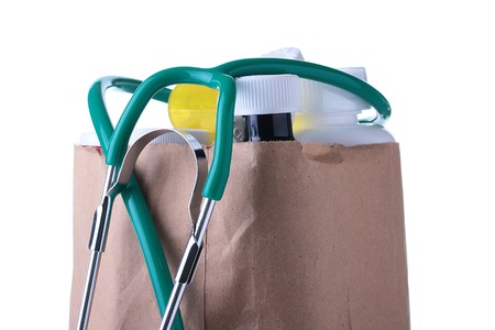 Medicines are combined in a paper package, the stethoscope from above lies.の写真素材