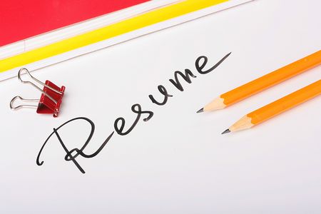 On a white background an inscription - Resume with two thick writing-books and pencils.