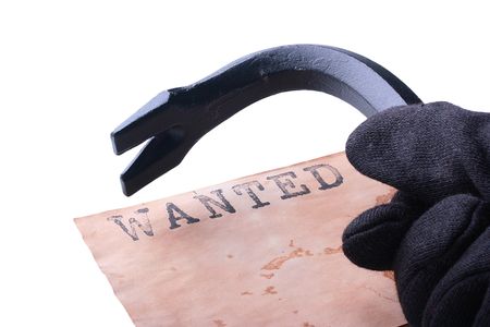 The hand in a black glove made of cloth holds crowbar.の写真素材