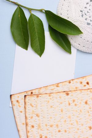 A white kippah and matzah next to a piece of white paper. Add your text to the paper.の写真素材