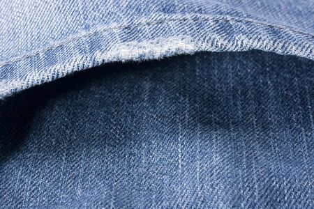 Pocket of trousers from a dark blue jeans material.