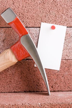 White piece of paper for a message next to a hammer. Add your text to the paper.の写真素材