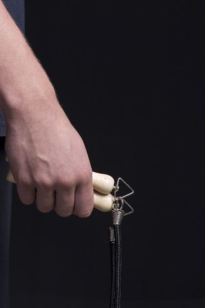 Human hand holding a jump rope on a black background.の写真素材
