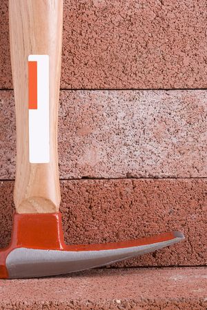 Stonemason's hammer on a background of red bricks.の写真素材