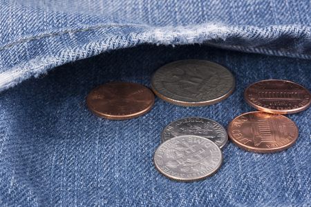 Metal coins in a pocket of dark blue jeans.の写真素材