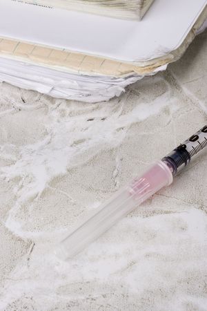 Syringe laying next to a student's notebook.