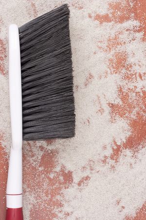 House cleaning, on a floor small sand simulating dust is scattered.