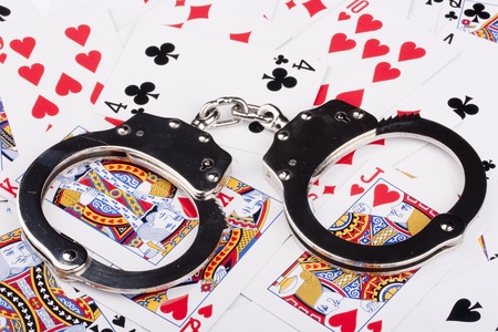 Handcuffs with things gaming - playing cards on a white background.のeditorial素材