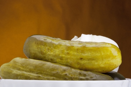 Pickled cucumbers with red onions in a white ceramic plate.の写真素材