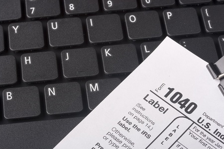 Keyboard laptop computer with a form 1040 for tax report.の写真素材