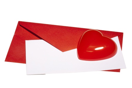 Red heart laying next to a red envelope with white paper on a white background.の写真素材