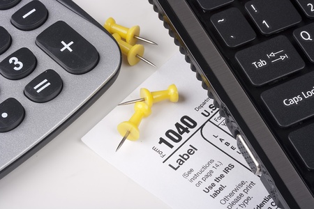 Keyboard laptop computer with a form 1040 for tax report.