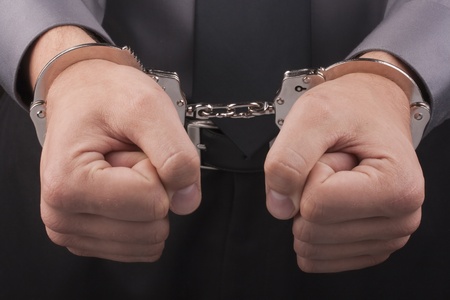 Arrest, close-up shot man's hands with handcuffs.